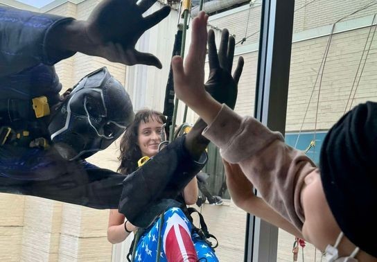 Image for story: Superheroes team up to clean windows, surprise pediatric patients in Huntington